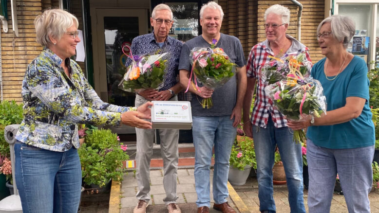 Het bestuur van de stichting Bewonersinitiatief Rosmolenwijk krijgt bloemen en bedankjes